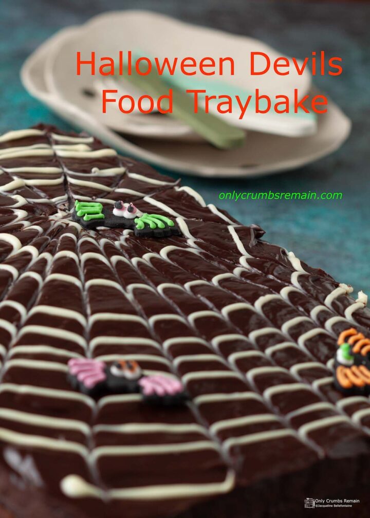 halloween devils food traybake cake with stack of ta plates behind.