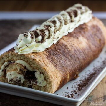 tiramisu swiss roll cake on a white plate.