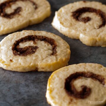 4 cooked cinnamon roll cookies on the work surface.