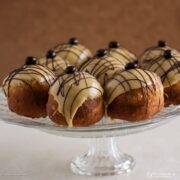 Coffee and Baileys doughnuts in a glass cake stand.