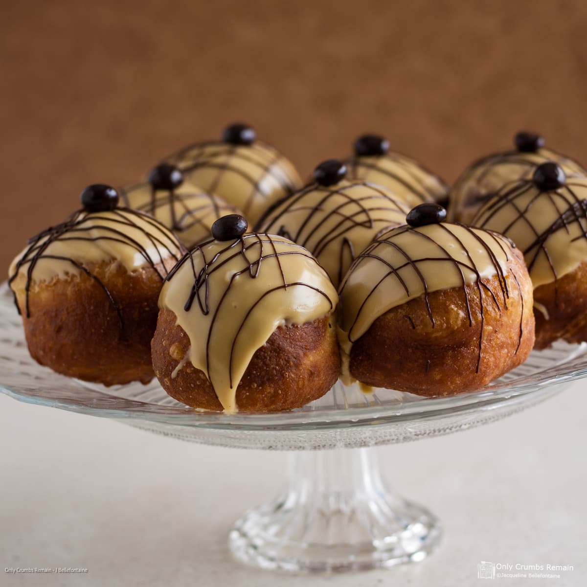 Coffee and Baileys doughnuts in a glass cake stand.